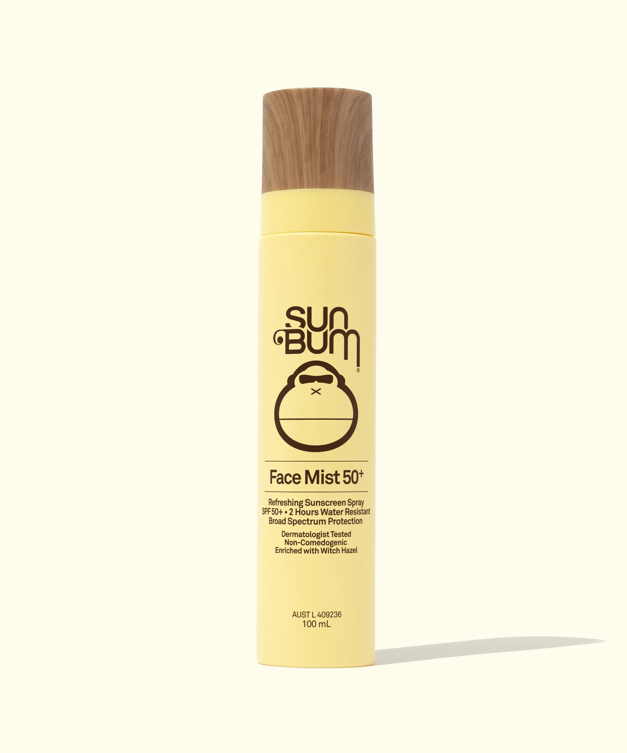 A bottle of Sun Bum Original SPF 50+ Face Mist with a yellow label and a wood-colored cap.