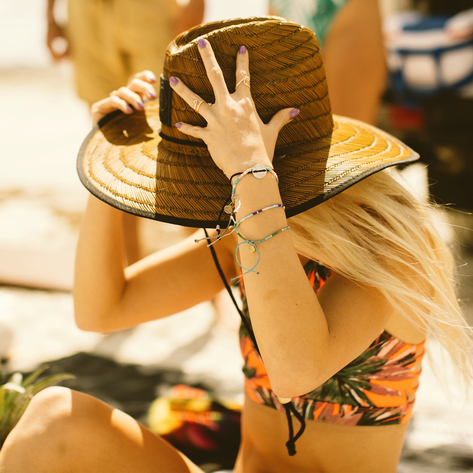 Woman wearing the Sonny Lifeguard Hat on a sunny beach, enjoying comfort and style. Sun Bum
