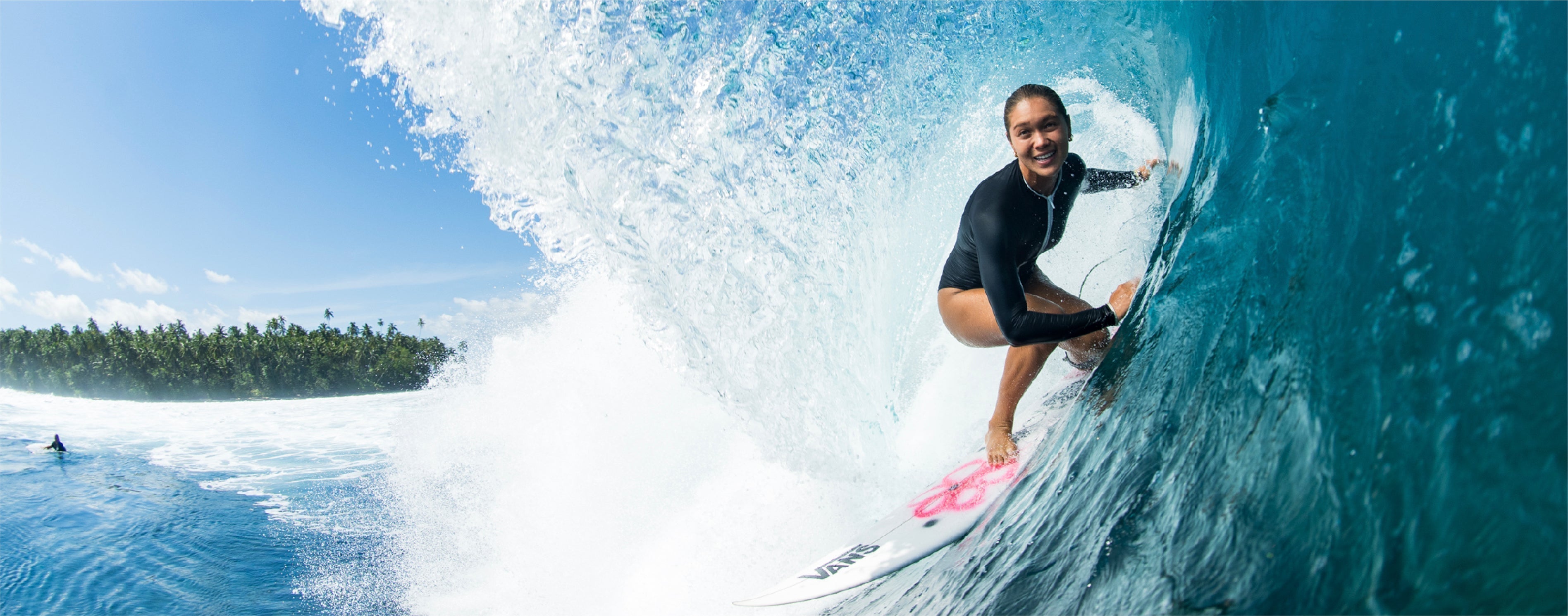 Person surfing on a wave with a Vans surfboard