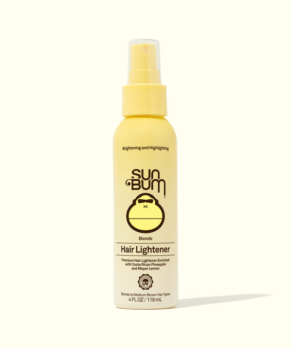 A bottle of Sun Bum Blonde Hair Lightener spray with a yellow label, designed for lightening hair naturally with pineapple and lemon scents.
