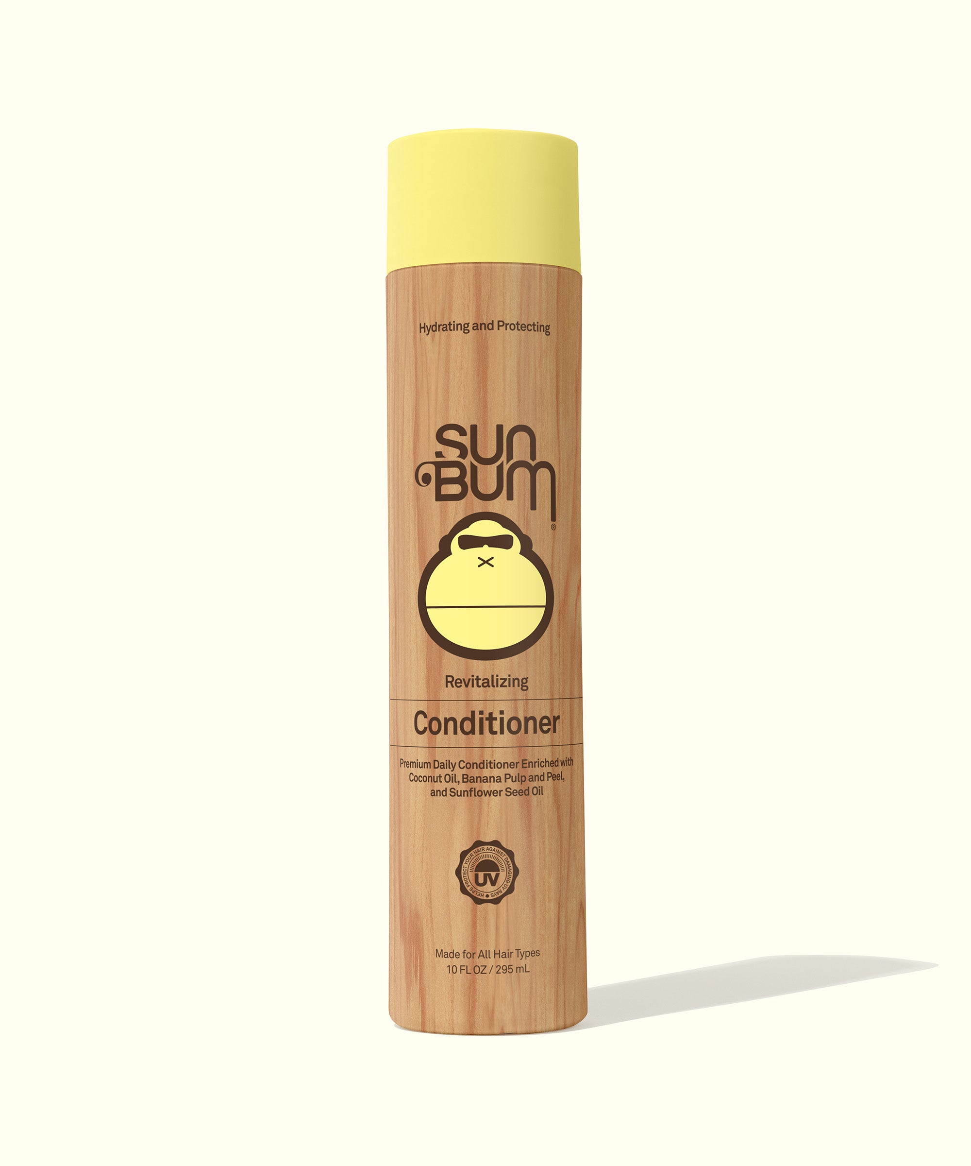 A bottle of Sun Bum revitalizing conditioner with a beige body and a yellow cap, labeled for hair care.