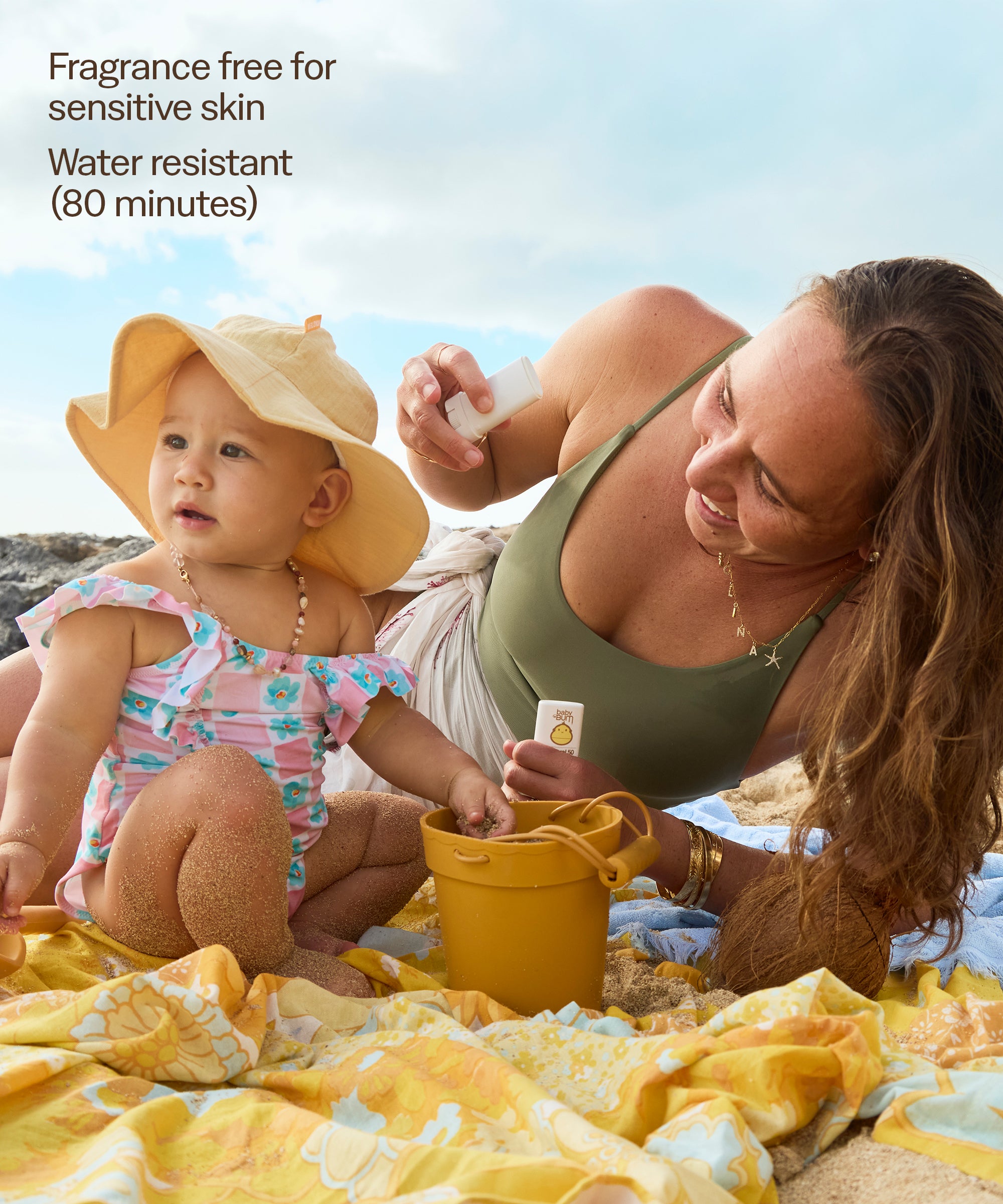 Woman and child at the beach with a product, text about fragrance-free and water resistance.
