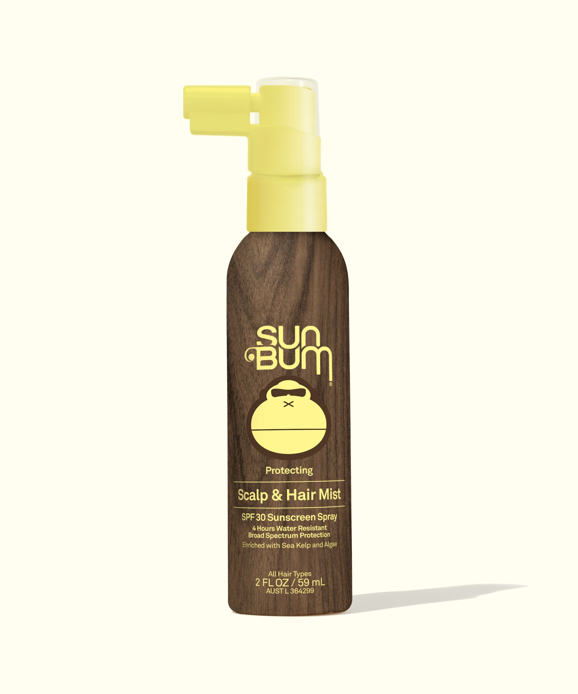 A bottle of Sun Bum Scalp & Hair Mist SPF 30 with a brown tint and a yellow pump.