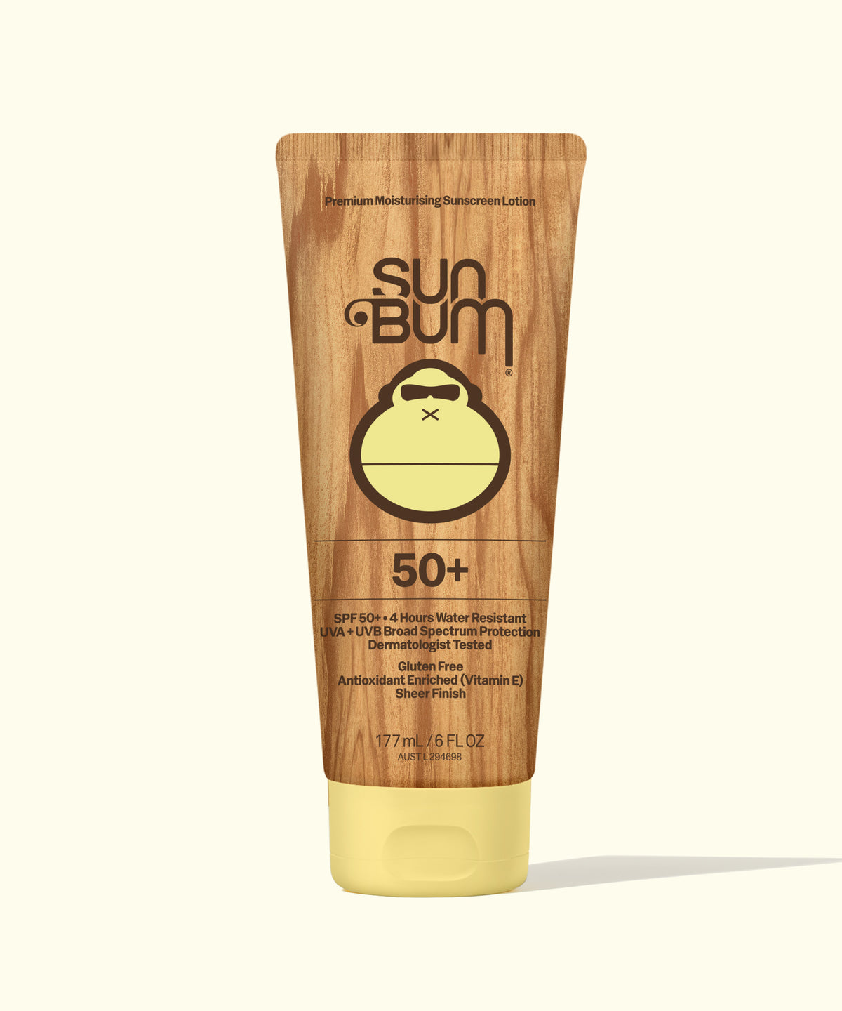 Sun Bum 50+ Premium Moisturizing Sunscreen Lotion in a 177 mL squeeze tube with a wood-grain pattern and a pale yellow cap, shown on a light cream background.
