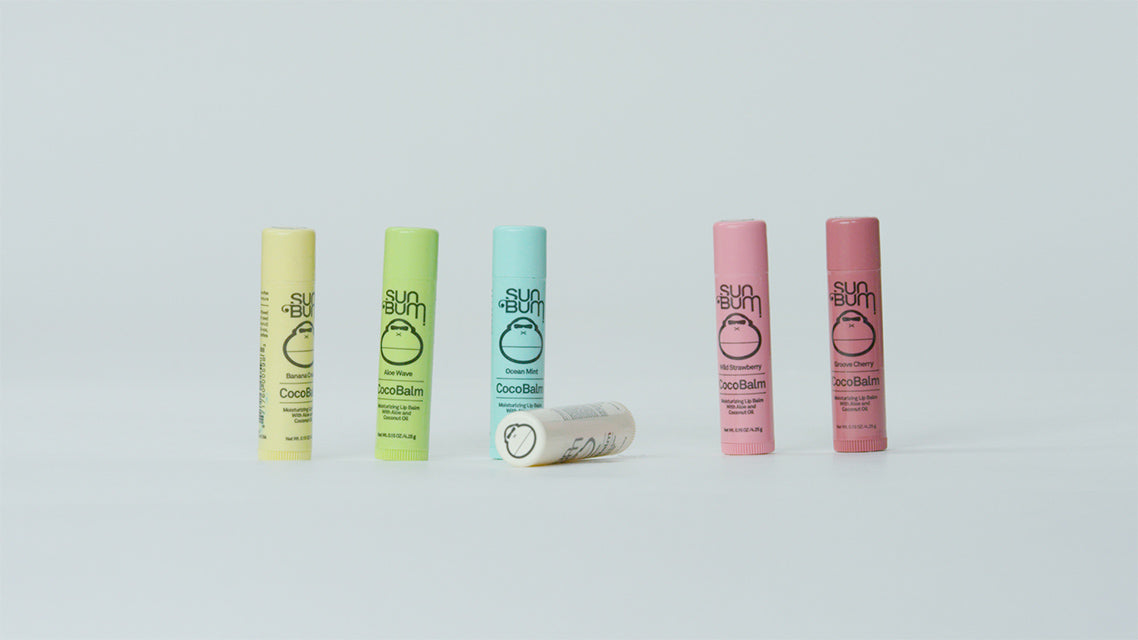 Set of Sun Bum lip balms in various colors on a light gray background