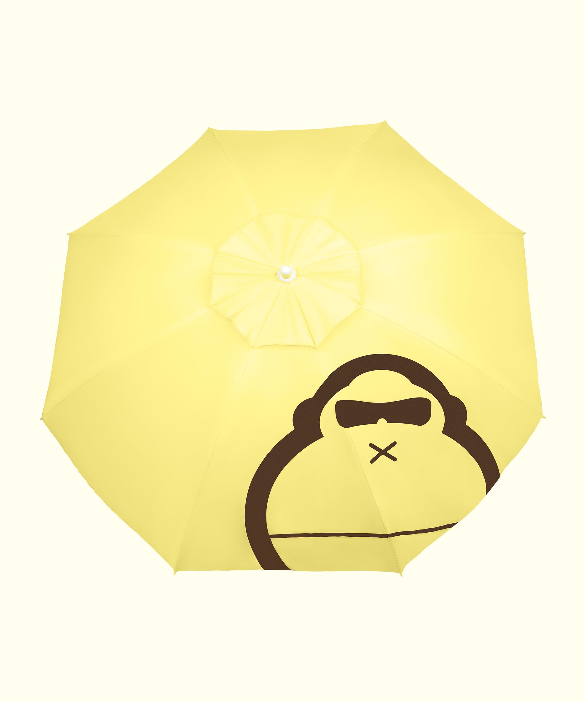 A yellow beach umbrella with a large sun icon and a face with sunglasses design in the center.