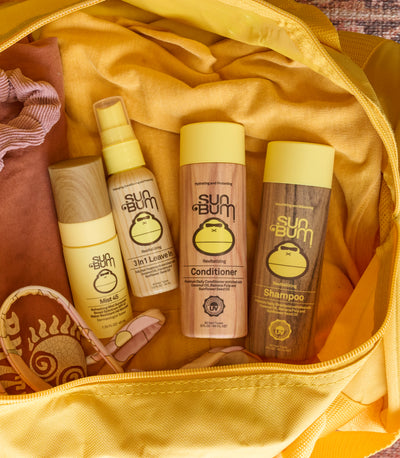 Sun Bum travel-sized hair and body products packed in a yellow bag, featuring the SB Travel Sized Products Collection – Sun Bum.